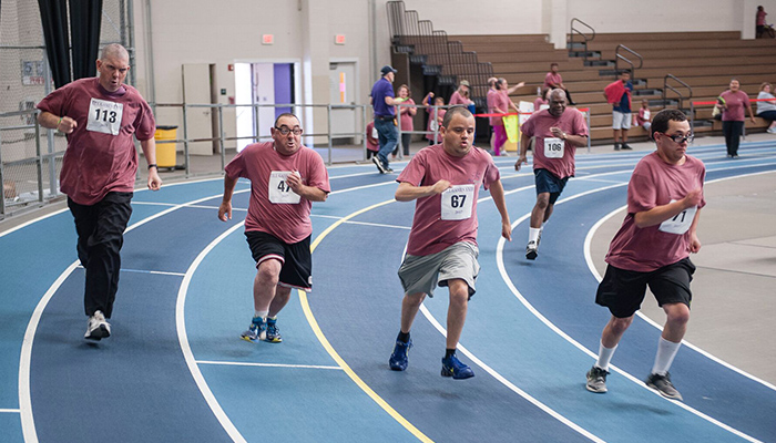 Till Games maroon shirts four men running a race