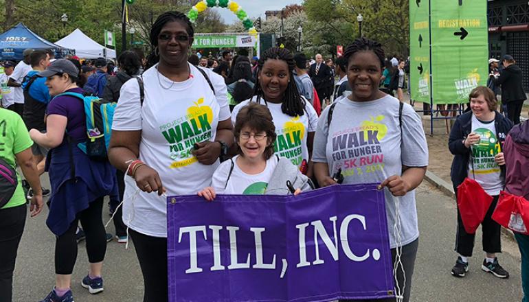 Walk for hunger participants holding a purple banner